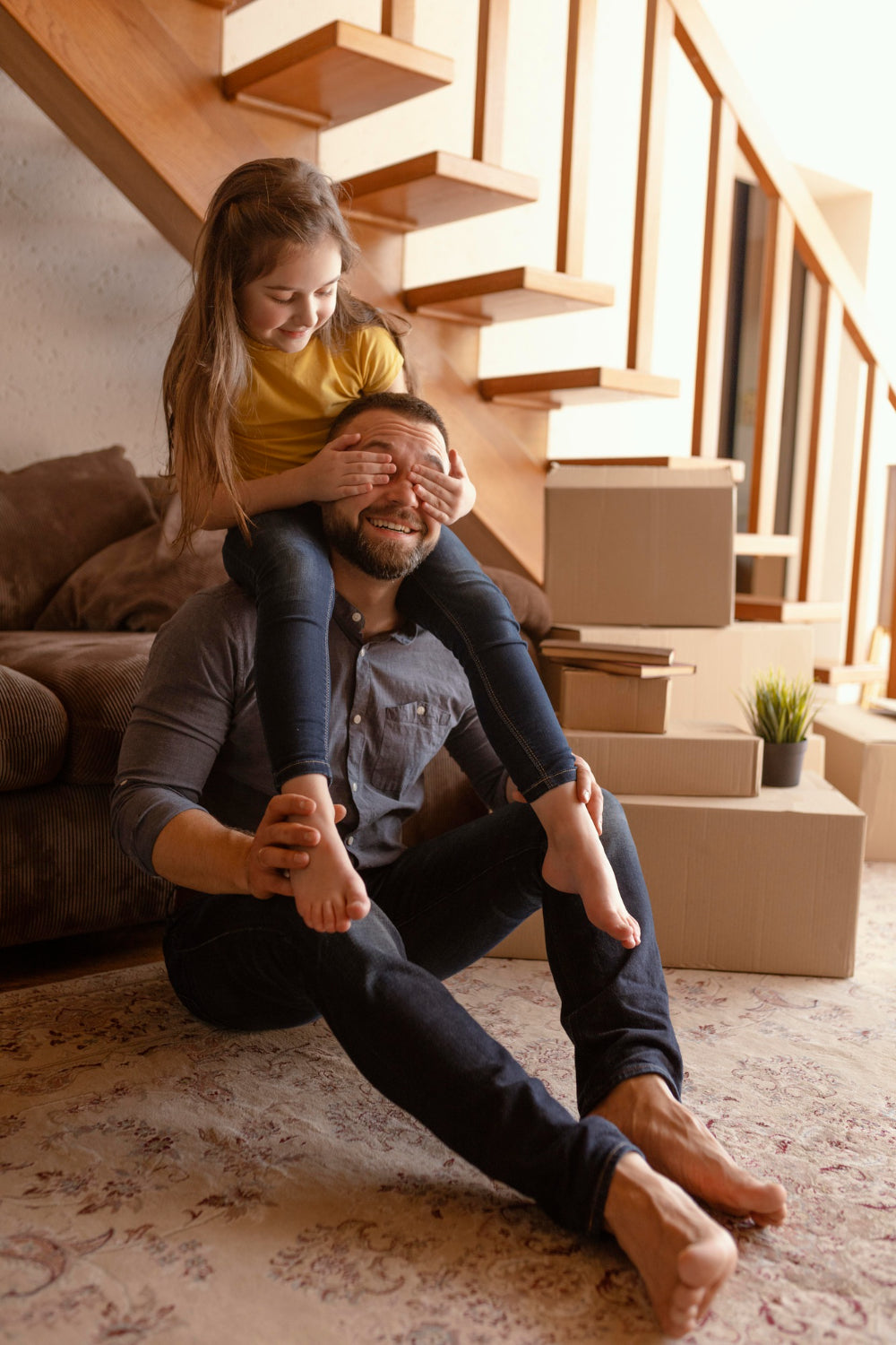 Man and woman playing a game of peek-a-boo in a living room with cardboard boxes.